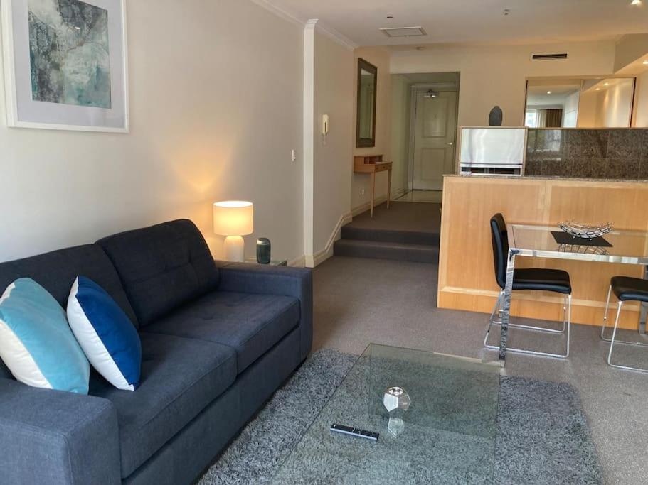 a living room with a couch and a table and a kitchen at CBD Corporate Apartment BON002810 in Sydney