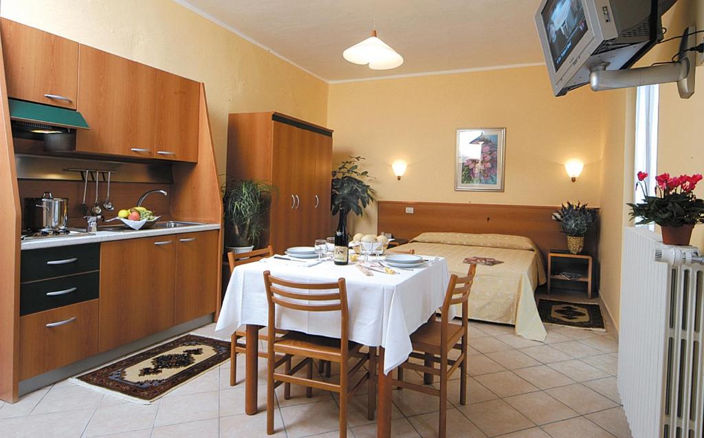 una cucina e una sala da pranzo con tavolo e letto di Casa Vacanze Provenzale a Torre Pellice