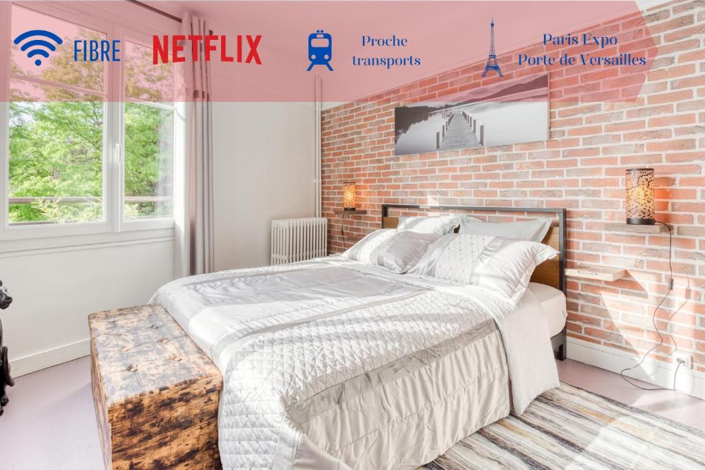 een slaapkamer met een bakstenen muur en een bed bij Détente et Découvertes en Pro ou en Famille in Vanves