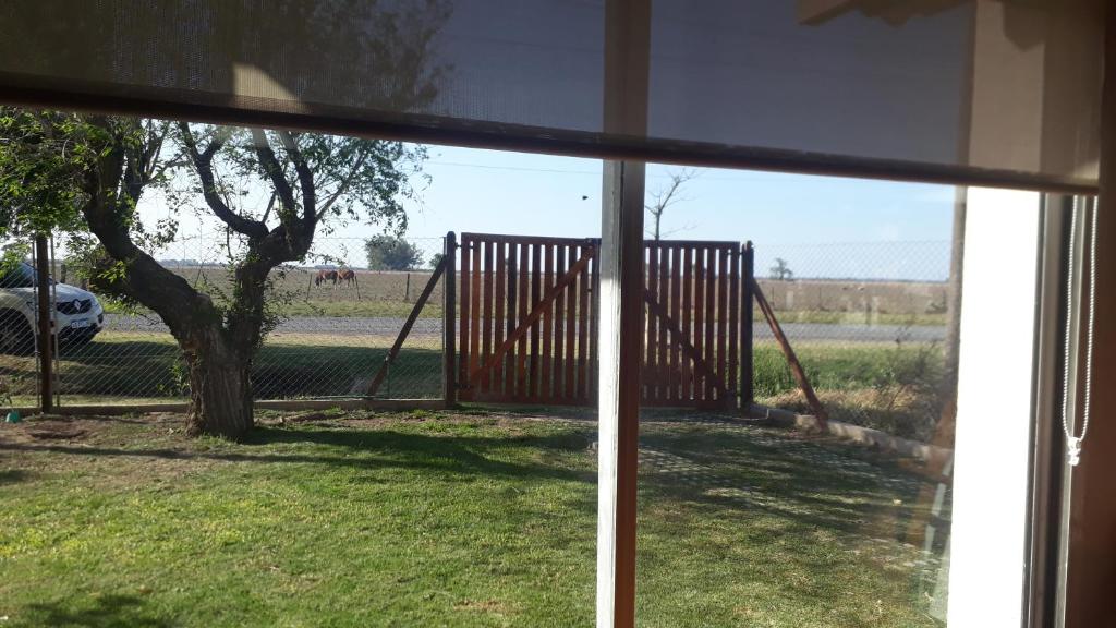 una ventana con vistas a un porche con columpio en casa de campo a 40 km de Rosario 