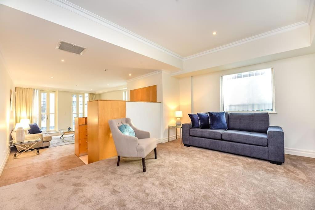 a living room with a couch and a chair at Huge Exec Apartment -Fantastic CBD Location B21001 in Sydney