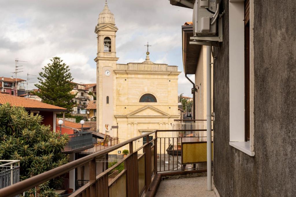uma igreja com uma torre de relógio ao fundo em Casa Venera sull'etna em Nicolosi