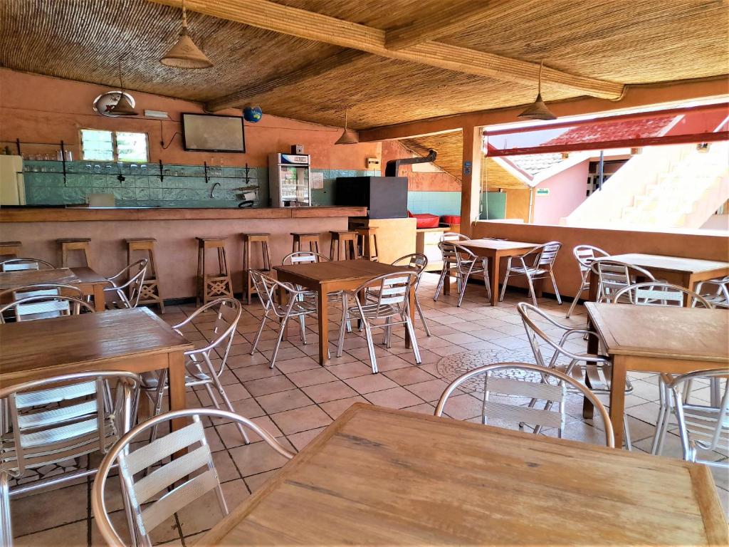 a restaurant with tables and chairs in a room at Auberge Le Baobab in Saly Portudal