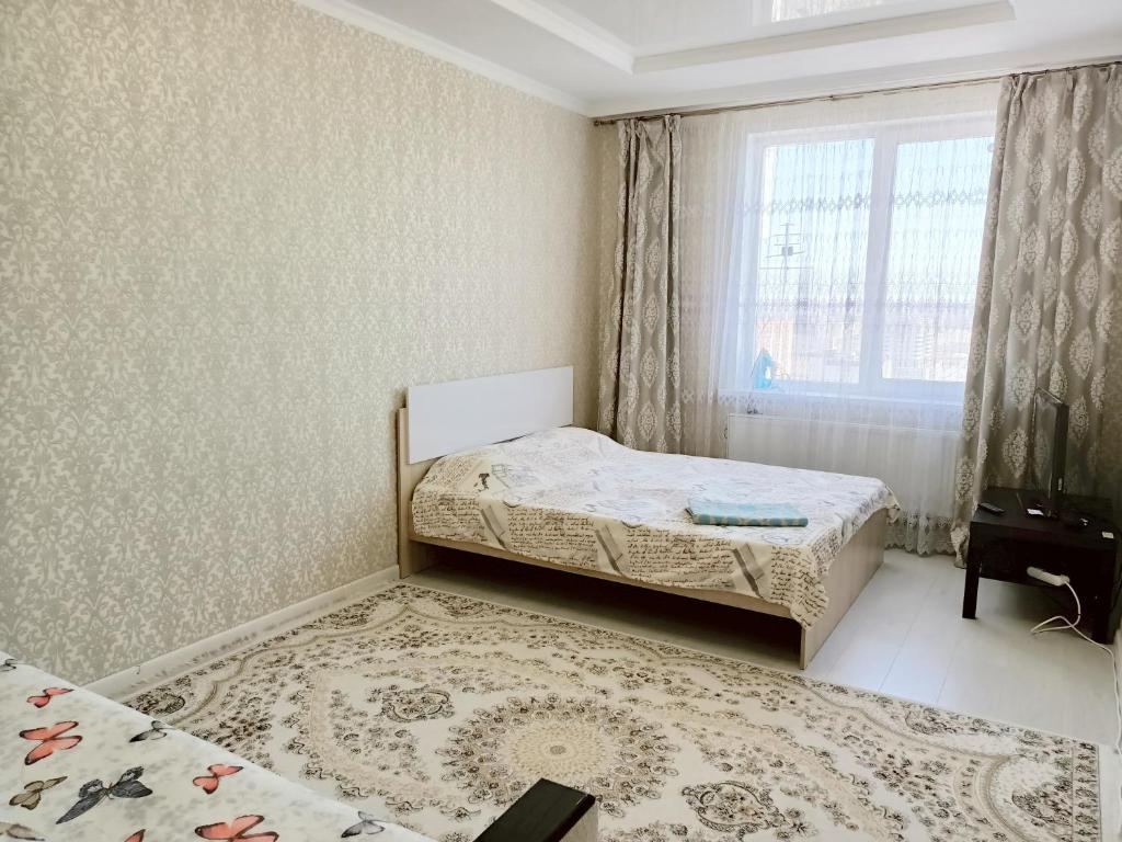 a bedroom with two beds and a window at Однокомнатная квартира в ЖК Millennium Park in Astana