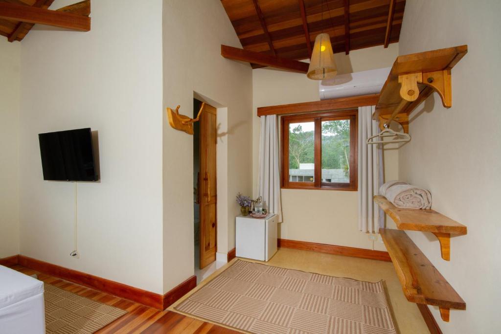 a living room with a staircase and a tv at Go Organic Club - Santo Antônio do Pinhal SP, Brasil in Santo Antônio do Pinhal