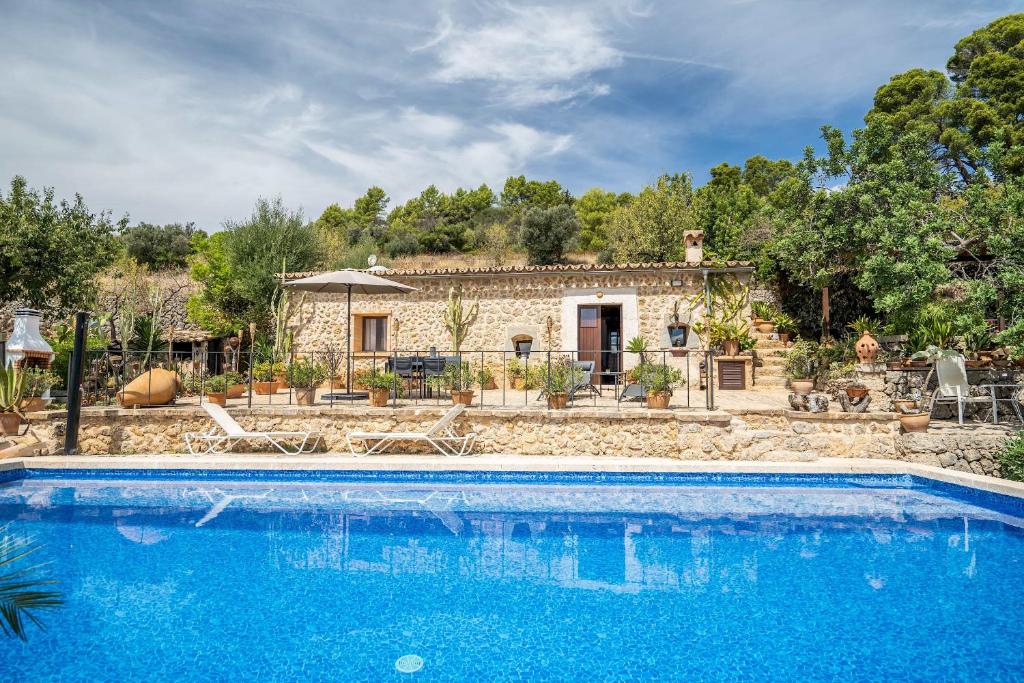 una villa con piscina di fronte a una casa di CAN PULIT - finca romántica para 2 con piscina y vistas en Selva Mallorca a Selva
