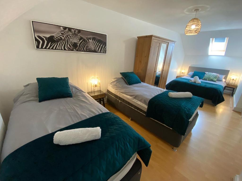 a bedroom with two beds and a zebra picture on the wall at Modern Spacious Flat In Ipswich - Sleeps 6 - Parking in Freston