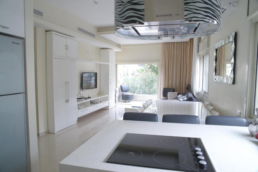 a kitchen and living room with a sink and a table at Dizengoff - Lovely family apartment 3 rooms. in Tel Aviv