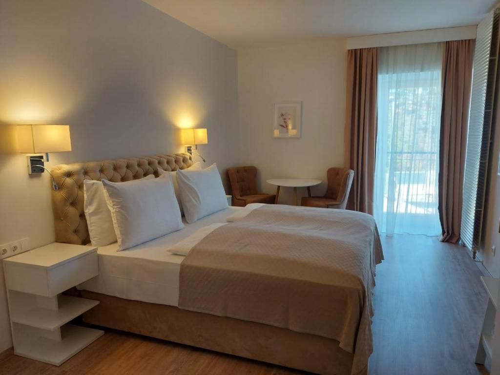 una habitación de hotel con una cama grande y una mesa en Gartenhotel Altmannsdorf en Viena