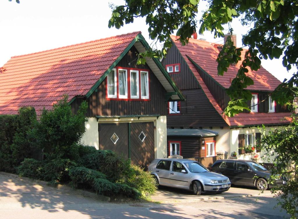 una casa con dos coches estacionados frente a ella en Ferienwohnung Lippe en Elbingerode