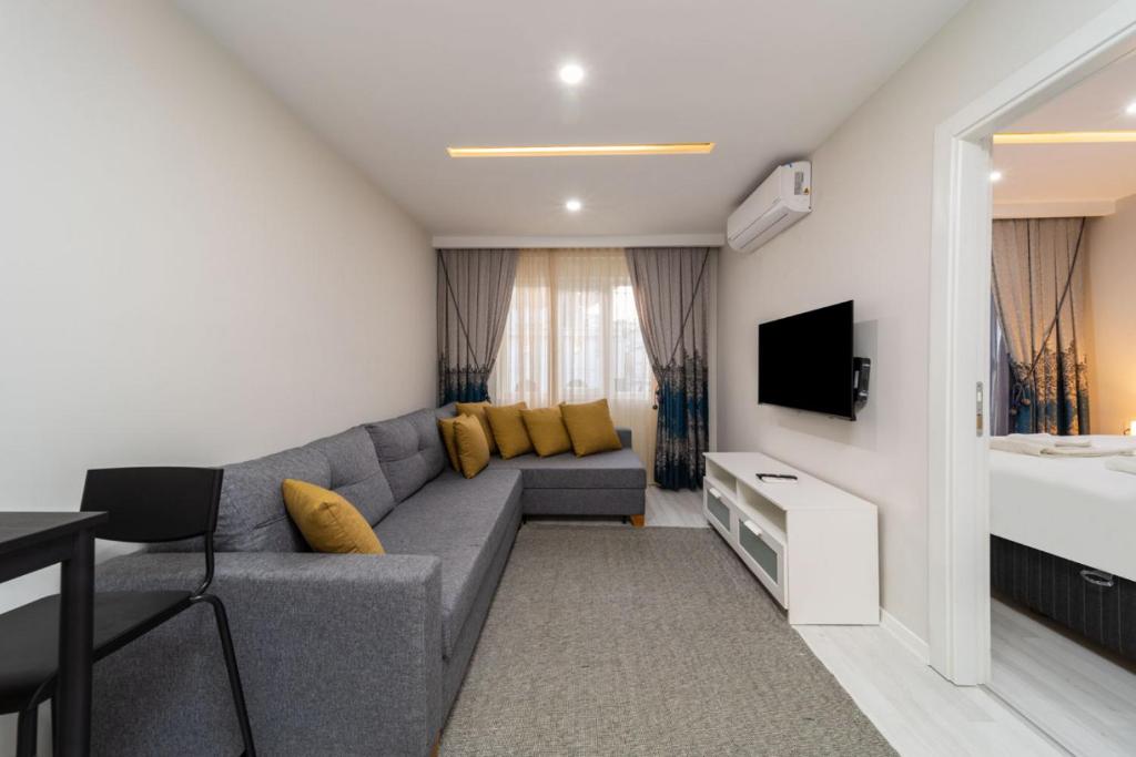 a living room with a gray couch and a television at Modern and Central Flat near Beach in Muratpasa in Antalya