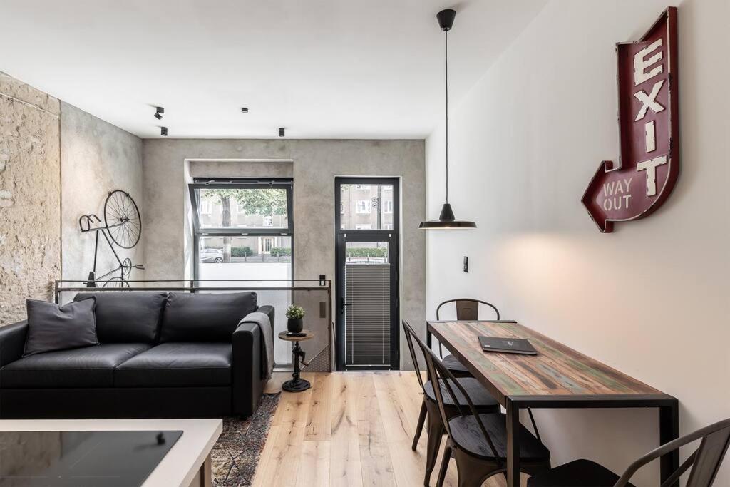 ein Wohnzimmer mit einem Sofa und einem Tisch in der Unterkunft Industrial 57sqm 3room maisonette apt near center in Berlin