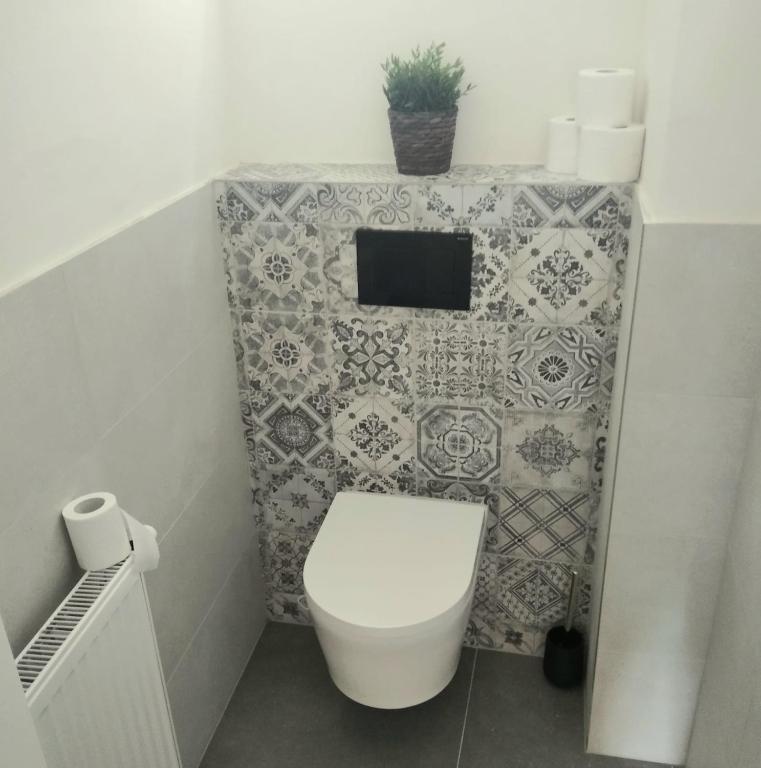 łazienka z toaletą i ścianą wyłożoną kafelkami w obiekcie Harmony Residence One WITH JACUZZI w Pradze