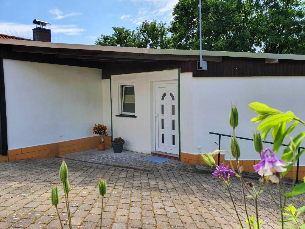 Casa con puerta blanca y patio de ladrillo en Haus Sonja, en Tanne