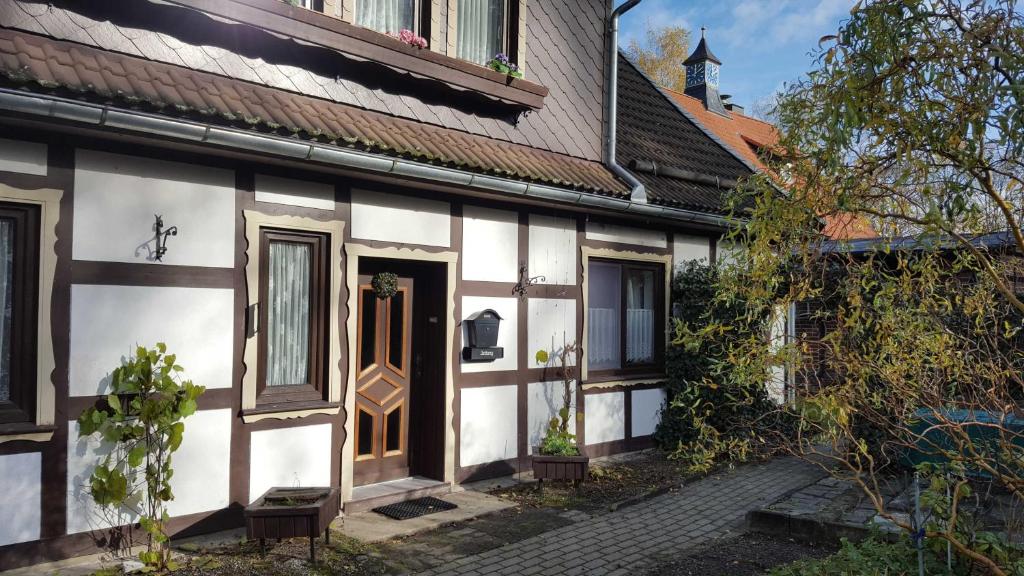 a white and brown building with a door at Harzhaus Sorge in Sorge