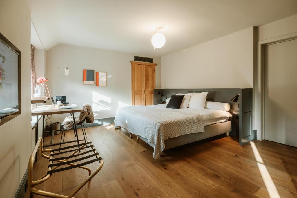 a bedroom with a bed and a desk in it at Auberge du Pêcheur in Sint-Martens-Latem