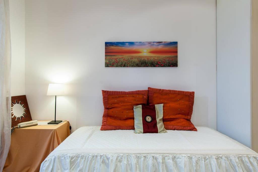 - une chambre avec un lit et des oreillers orange dans l'établissement Appartamento Via Rovetta, à Milan