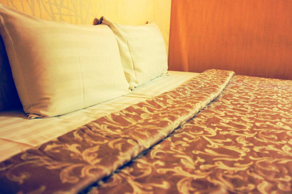 a close up of a bed with a pillow at Li Duo Hotel in Tainan