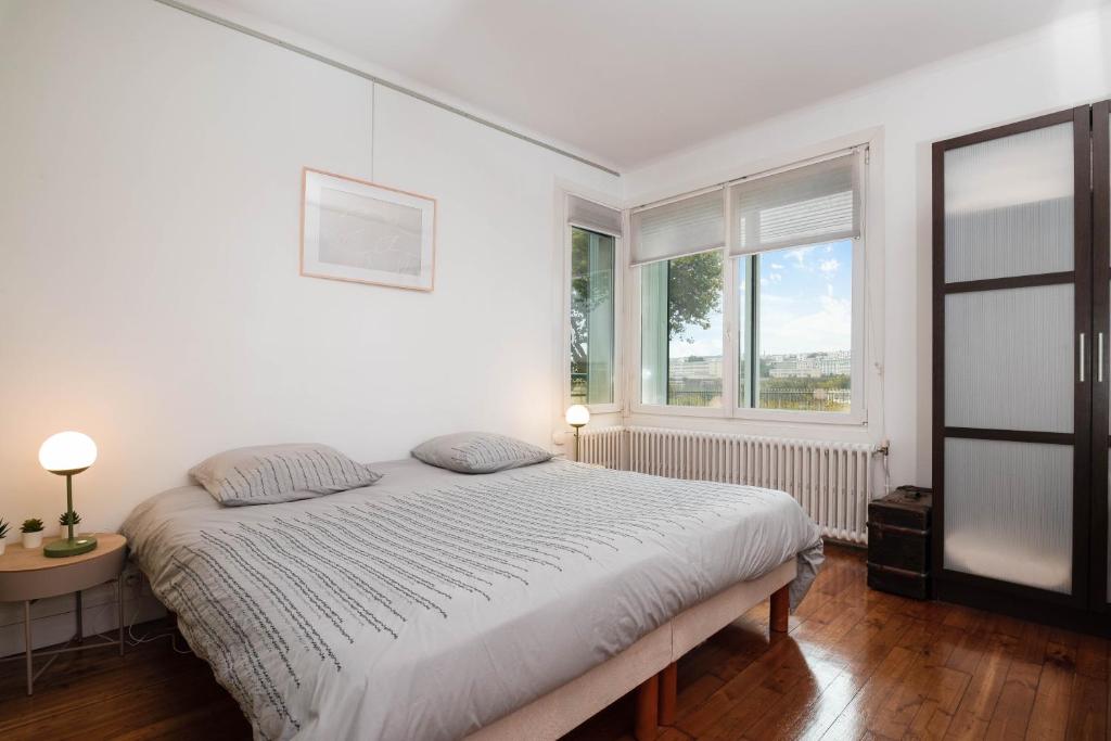 a white bedroom with a bed and a window at Brest : charmant appartement hypercentre in Brest