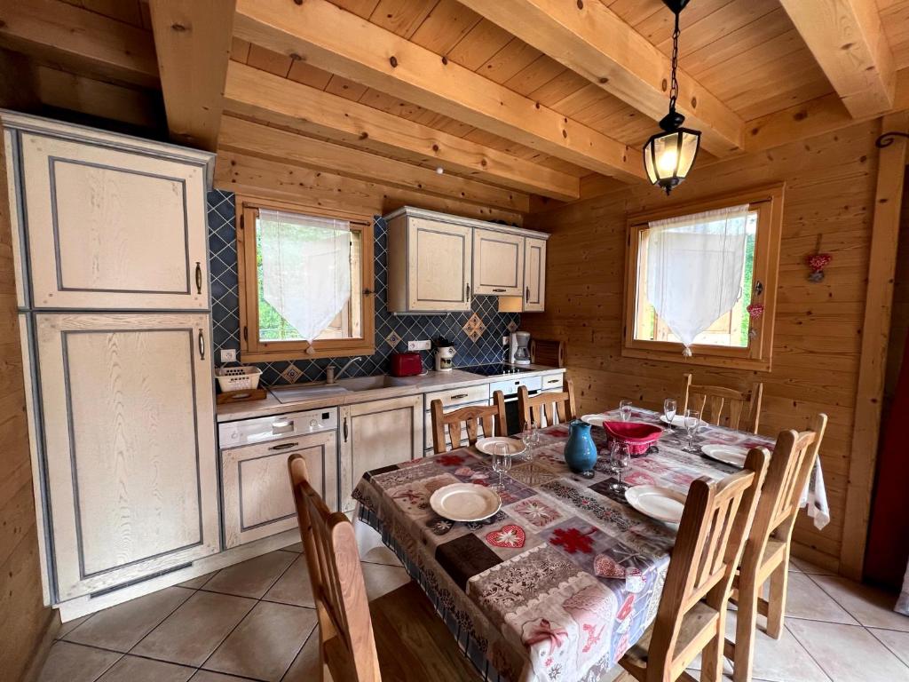 eine Küche mit einem Tisch und Stühlen in einer Hütte in der Unterkunft Aulp de Suz 2 - Chalet avec vue in La Clusaz