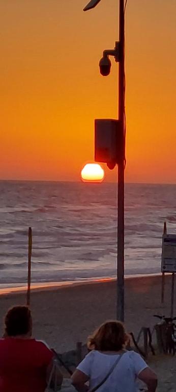 two people sitting on the beach watching the sunset at CasAmare in Torvaianica