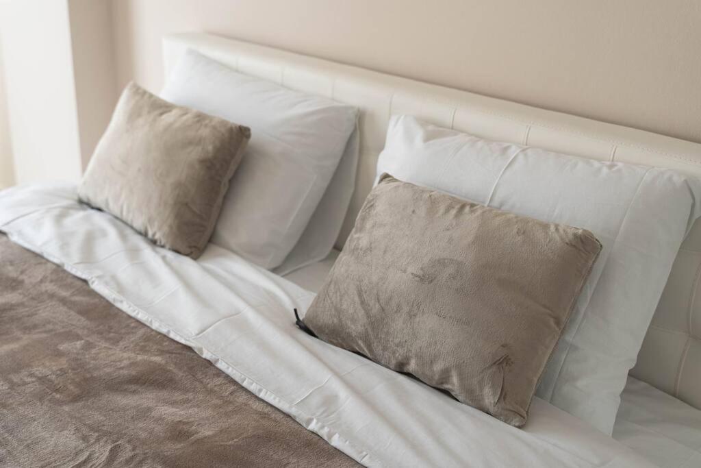 a white bed with four pillows on it at RentWill apartments Milky Way in Chişinău