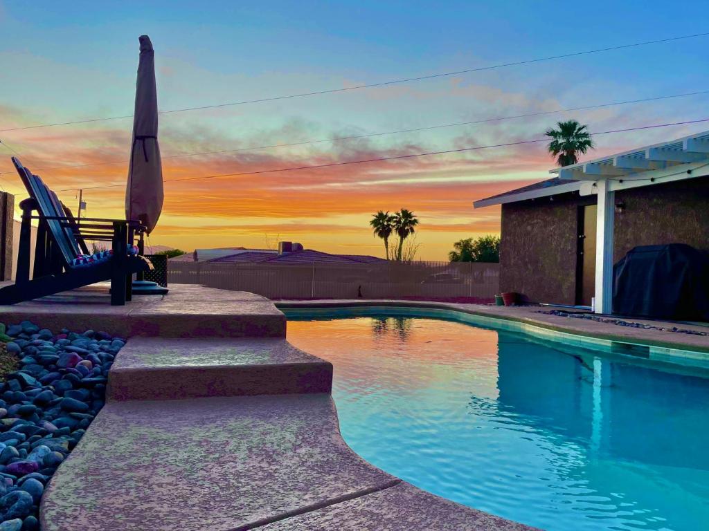 einen Pool mit Sonnenuntergang im Hintergrund in der Unterkunft Welcome to Casa Azul Havasu, with Pool Spa, new remodel, close to Ohv access in Lake Havasu City