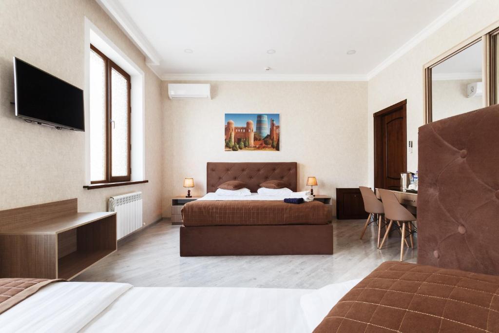 een hotelkamer met een bed en een tafel en stoelen bij ELDI Hotel in Tasjkent