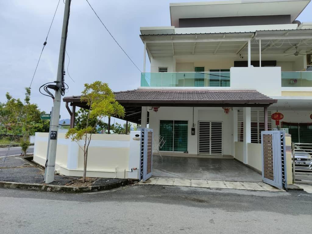 a white building with a parking lot in front of it at Prestij 3 Homestay, Balik Pulau in Balik Pulau