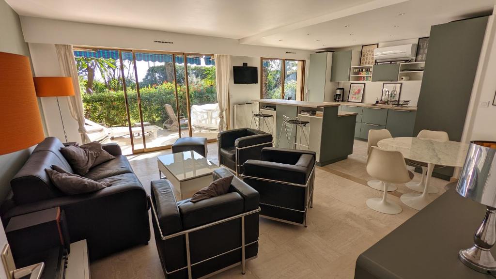 a living room with a couch and chairs and a kitchen at Eden Park 3 pièces 4 étoiles 100m des Plages Piscines SPA Parking in Cannes