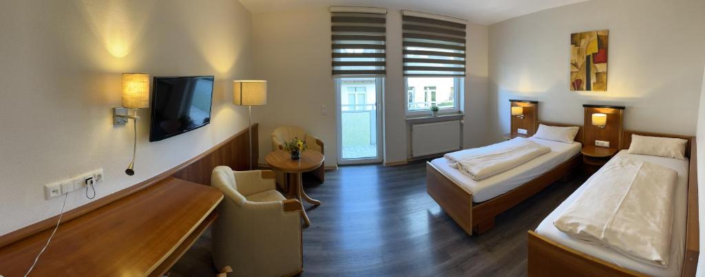 um quarto de hotel com duas camas e uma televisão em Hotel Carle em Marburgo