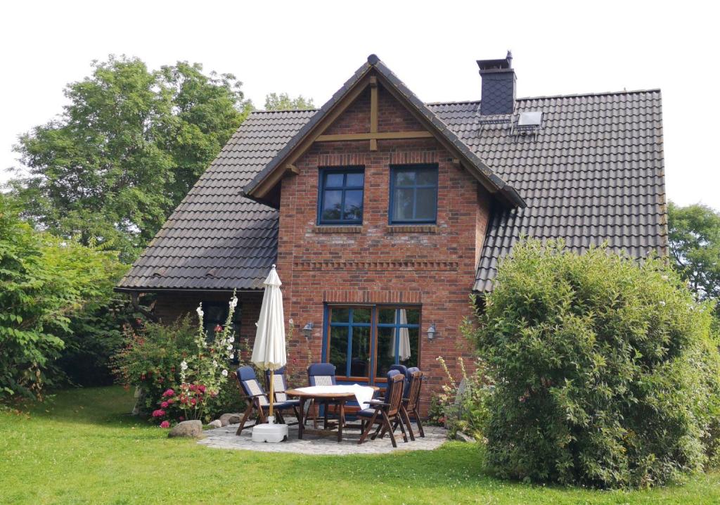 ein Haus mit einem Tisch und Stühlen im Hof in der Unterkunft Ferienhaus Arkona Putgarten in Putgarten