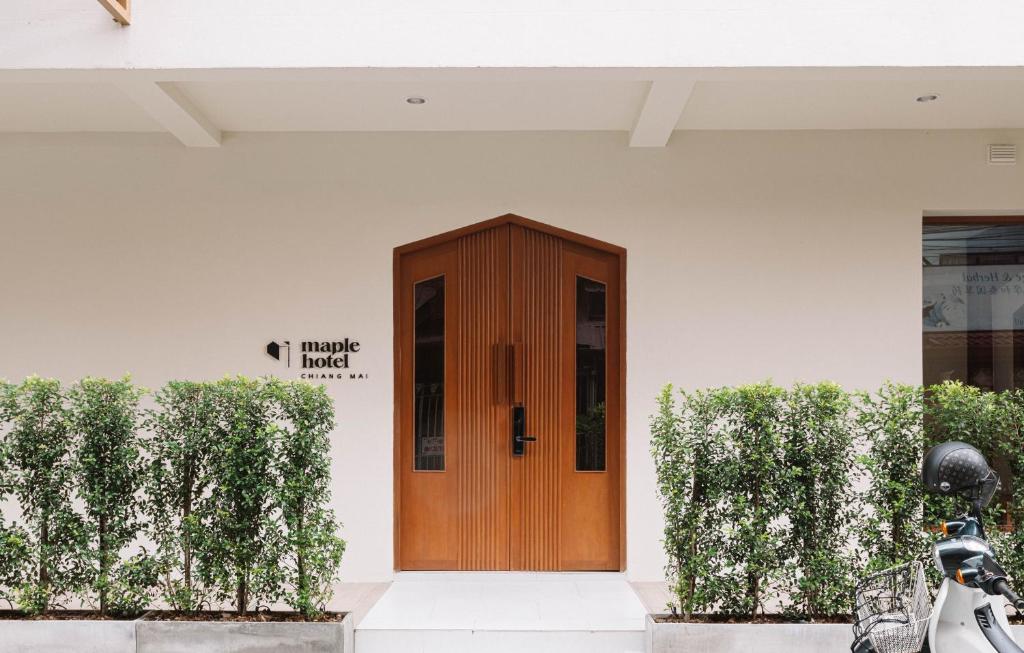uma porta de madeira na lateral de um edifício em Maplewood Hotel Chiangmai em Chiang Mai