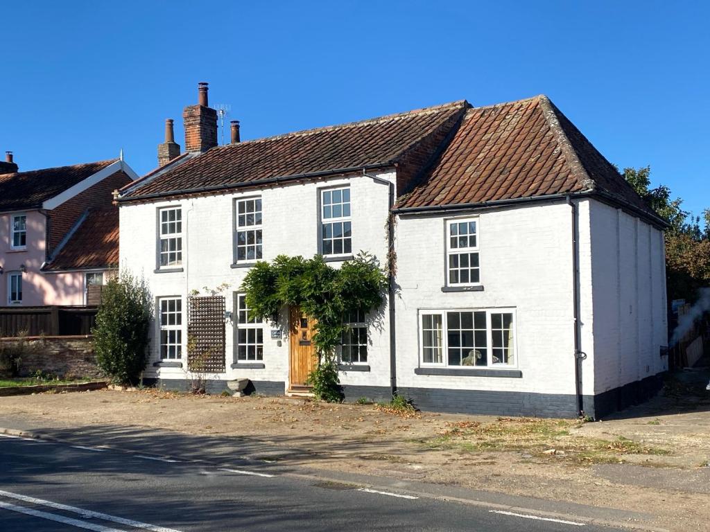 una casa blanca al lado de una calle en Carlton Cottage Country Retreat - Perfect for Ipswich - Aldeburgh - Southwold - Thorpeness - Sizewell B - Sizewell C - Sleeps 13 en Little Glenham