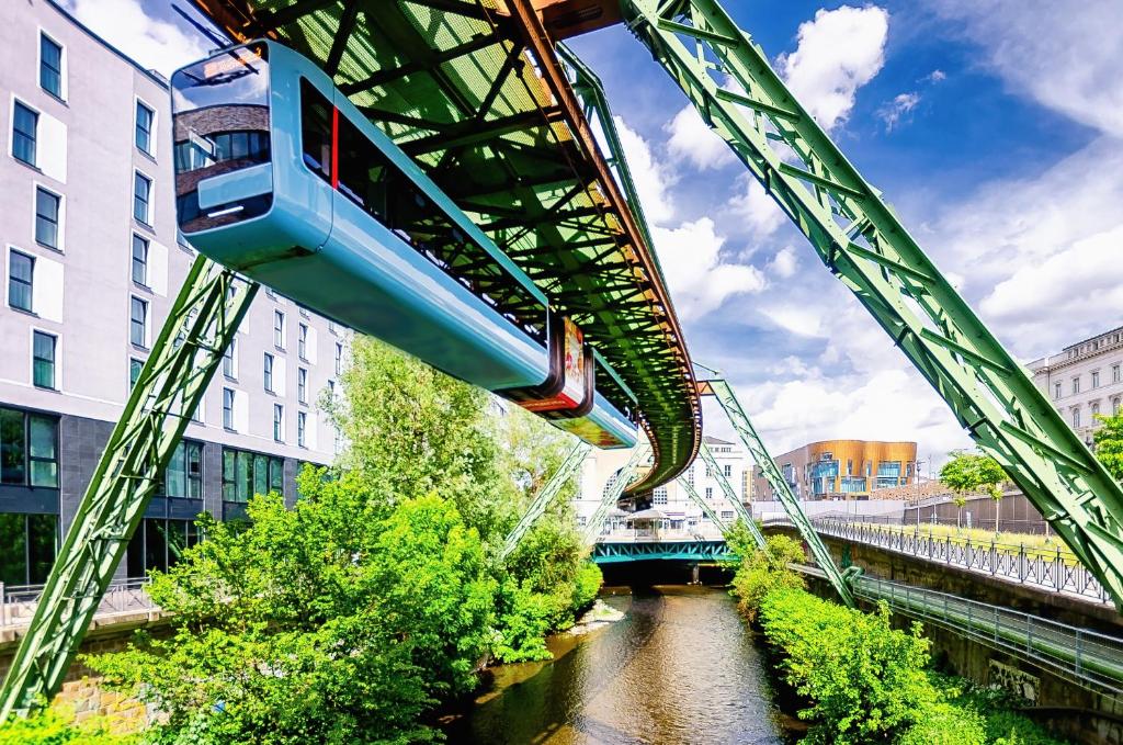 un tren en un puente sobre un río en Wu02 - WuTAL- 75qm -Single Beds, en Wuppertal