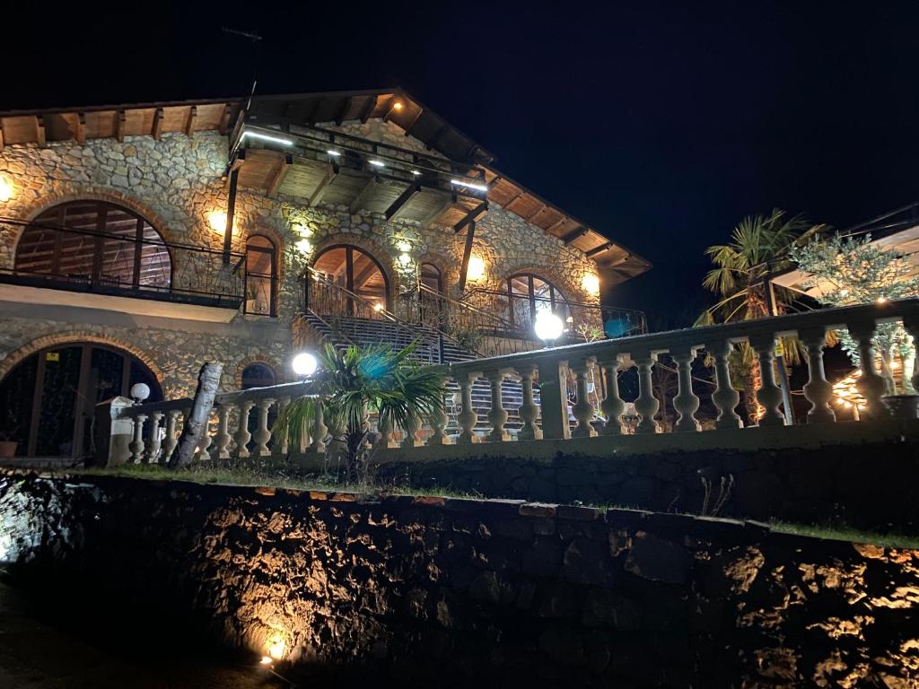a stone building with lights on a fence at night at Il Tramonto in Shirokë