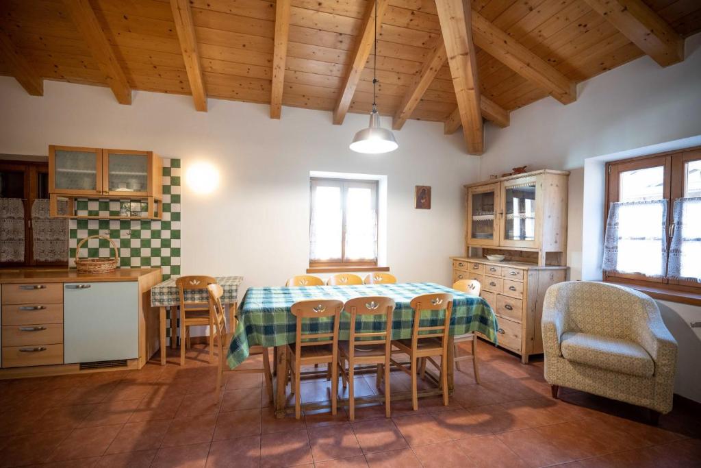 cocina y comedor con mesa y sillas en Cesa Meida 4, en Pozza di Fassa