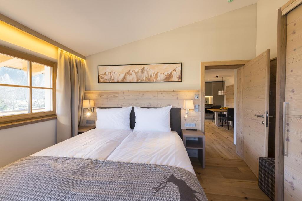 蒂羅爾－基希貝格的住宿－Alpen Chalet Dorfwies，一间卧室配有一张带白色床单的大床