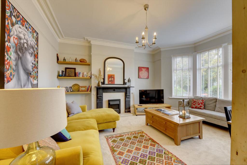 a living room with yellow furniture and a fireplace at Stylish 2 Bedroom Maisonette With Parking in Harrogate