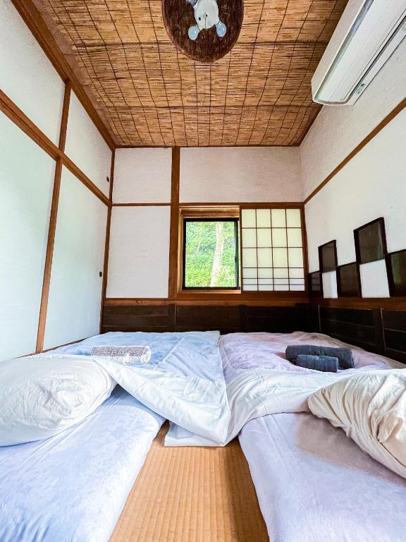 Postel nebo postele na pokoji v ubytování 古民家宿Tani House Itaya -セルフチェックイン