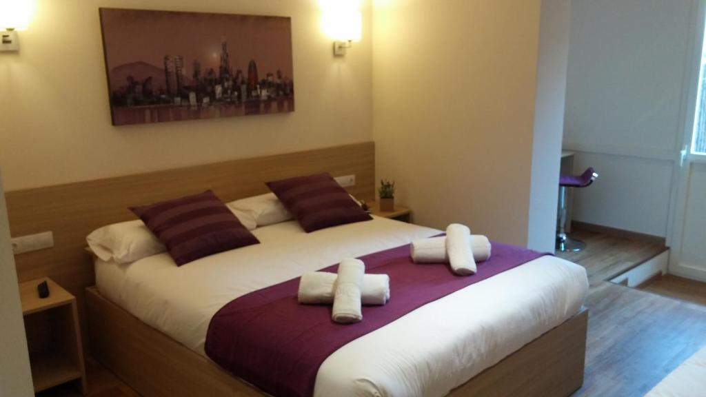 1 dormitorio con 1 cama grande y 2 almohadas en Hostal Barcelona Travel, en Barcelona