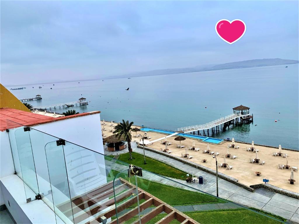 een uitzicht op een strand en een pier met een hart in de lucht bij Suite 1ra Fila Vista Bahía - 100 Metros Las Velas 601 T1 in Paracas
