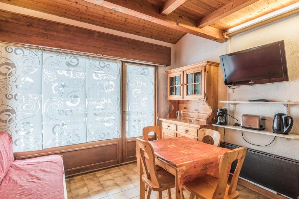 ムジェーヴにあるCharming flat with balcony at the foot of the slopes in Megève - Welkeysのキッチン(木製テーブル付)、大きな窓が備わります。