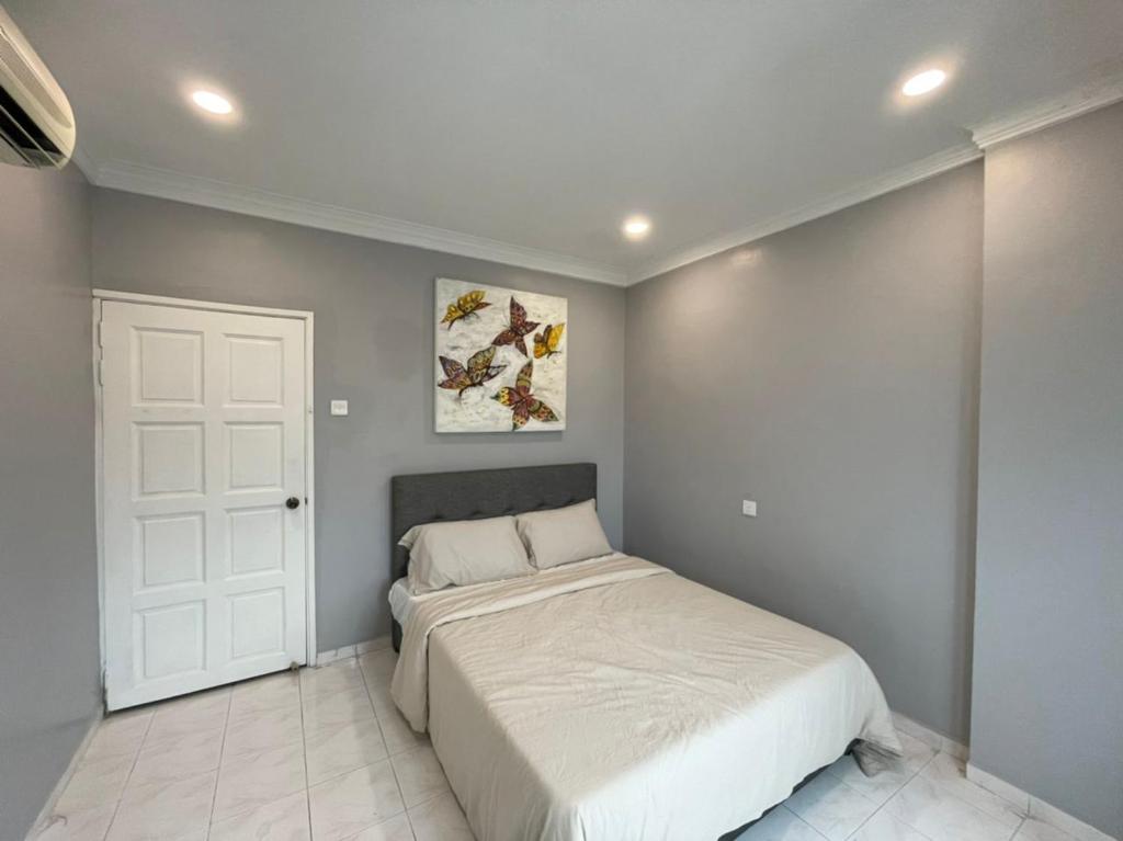 a bedroom with a white bed and a white door at The Penthouse in Kuah