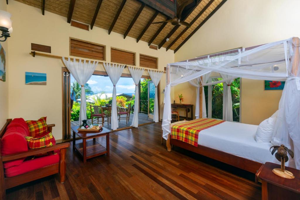una camera con un grande letto e un balcone di Tet Rouge Resort a Soufriere