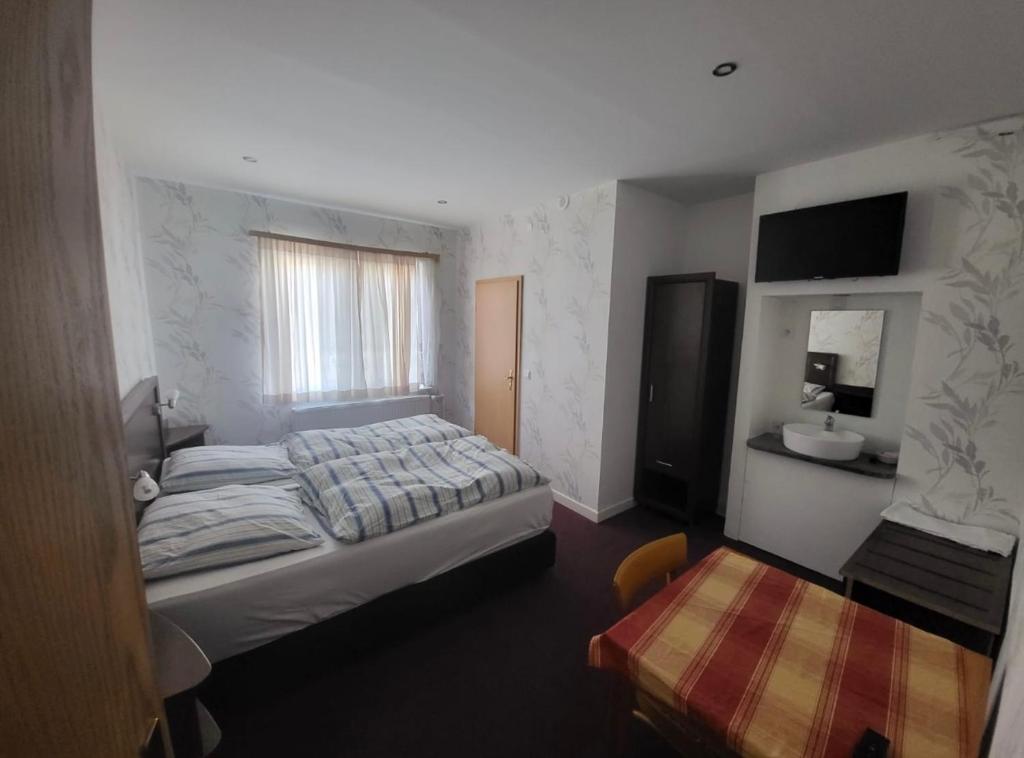 ein Schlafzimmer mit einem großen Bett und einem Fenster in der Unterkunft Hotel Zum Ritter in Staufenberg