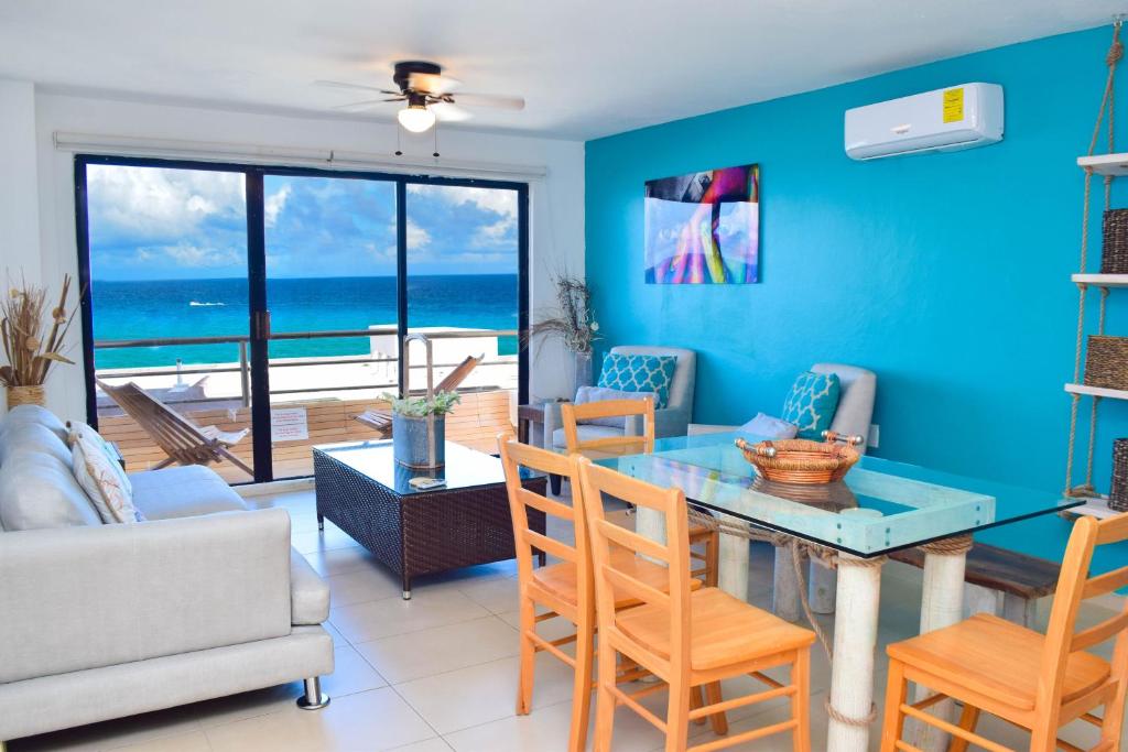 - un salon avec une table et des chaises donnant sur l'océan dans l'établissement Ocean view apartment, best beach area, 3 bedrooms, à Cancún