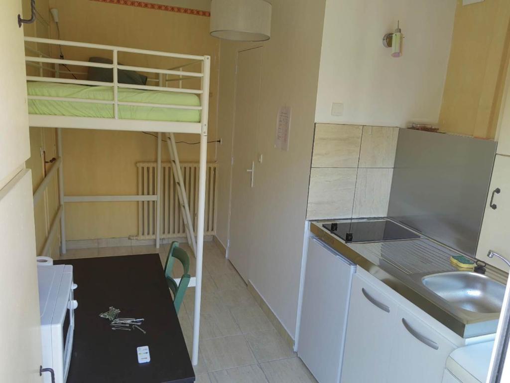 - une petite cuisine avec des lits superposés dans une chambre dans l'établissement Mini studio entre Paris et Disney, parking et Wifi gratuit, à Neuilly-Plaisance