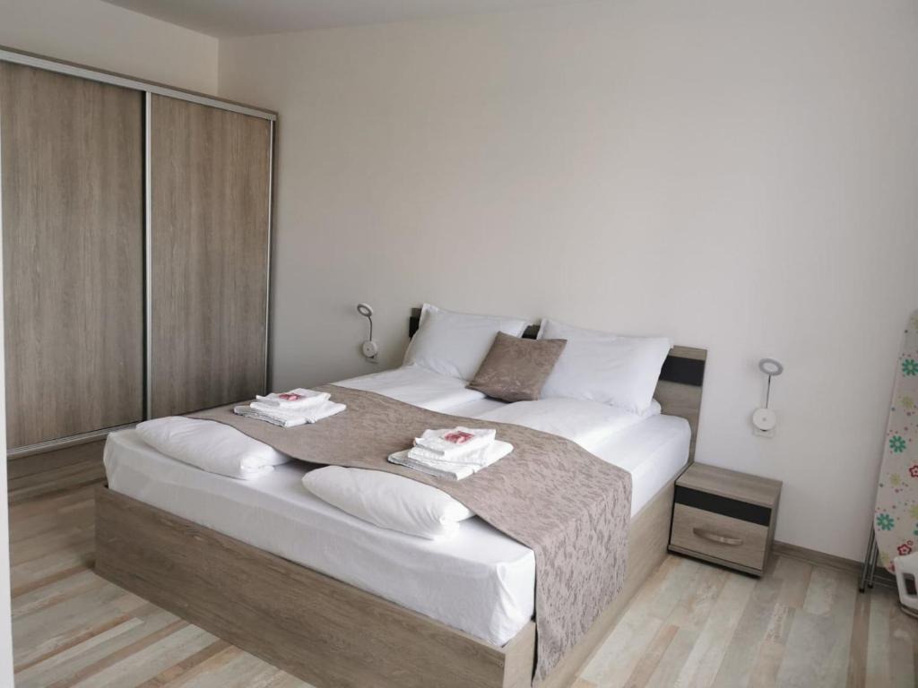 a bedroom with a large bed with white sheets at Апартамент Time for us in Velingrad