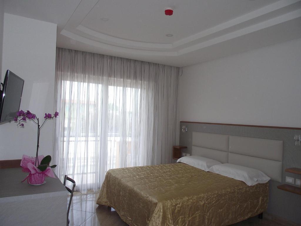 a bedroom with a bed and a large window at Il Girasole in Terracina